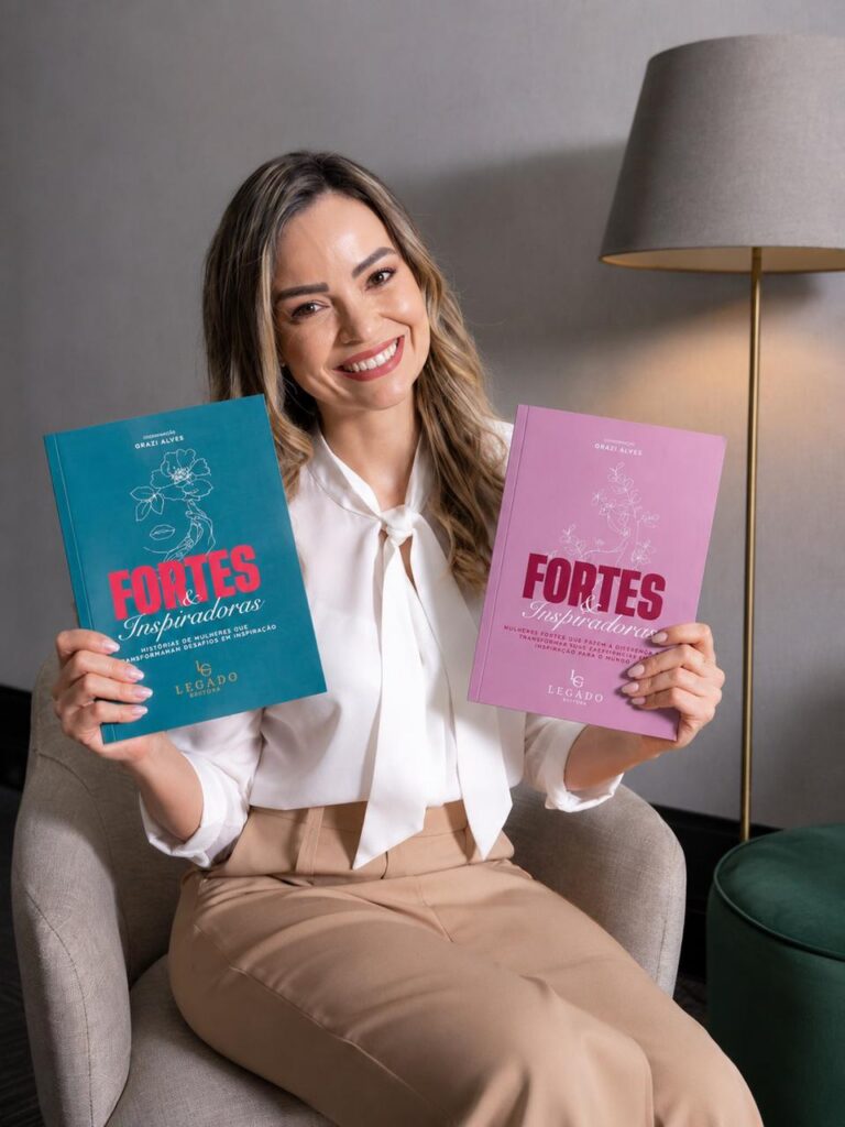 Luciana Muniz segurando os dois volumes da coletanea Fortes e Inspiradoras